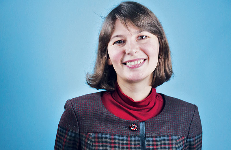 Smiling young woman with medium-length brown hair wearing professional attire