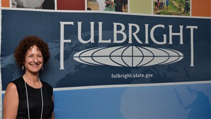 Betsey poses in front of the Fulbright sign.