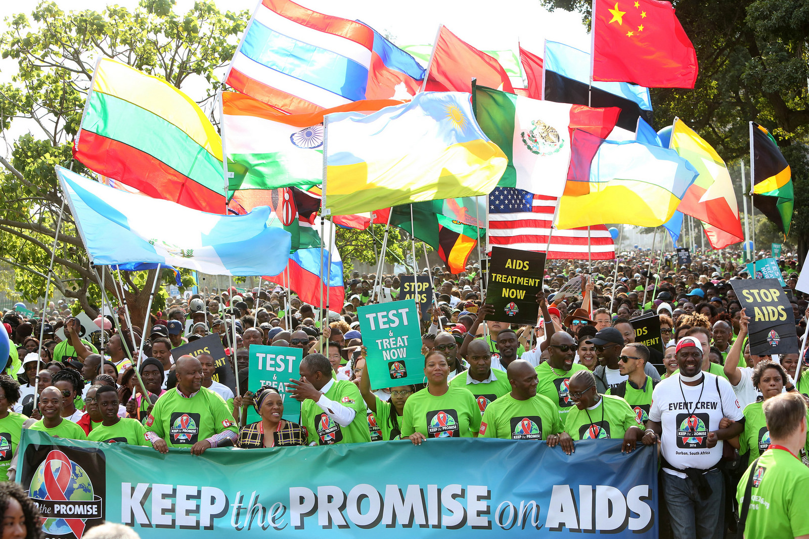 holding banner that says keep the promise on AIDS