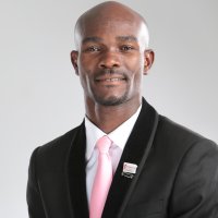 Headshot of young man wearing suit with pink tie