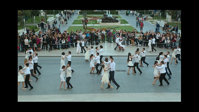 Dancers waltz together in an Armenian square