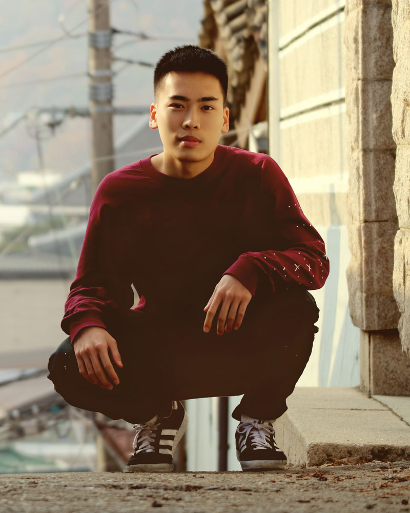 Young man squatting down on a city street