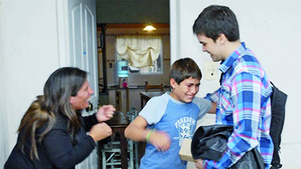 National Youth Science Camp alumnus Gino Tubaro presents an 11 year-old boy with a prosthetic hand he created using a 3D printer.