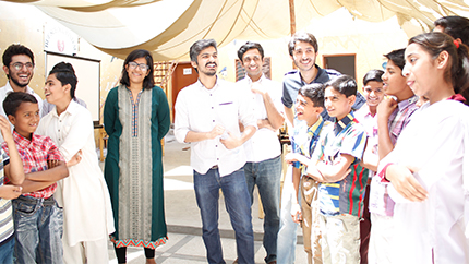 Organizers and participants enjoying a light moment during a role-playing activity at an ‘Aghaaz-e-Ravvish’ workshop at Mashal Model School