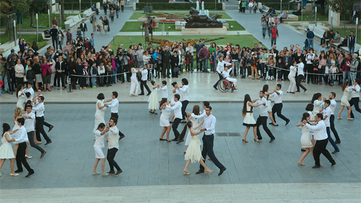 Dancers waltz together in an Armenian square