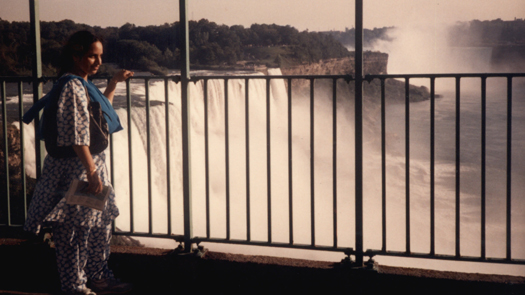 Woman standing on a covered platform overlooking a waterfall