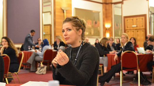 Young woman with a microphone talking in a conference room