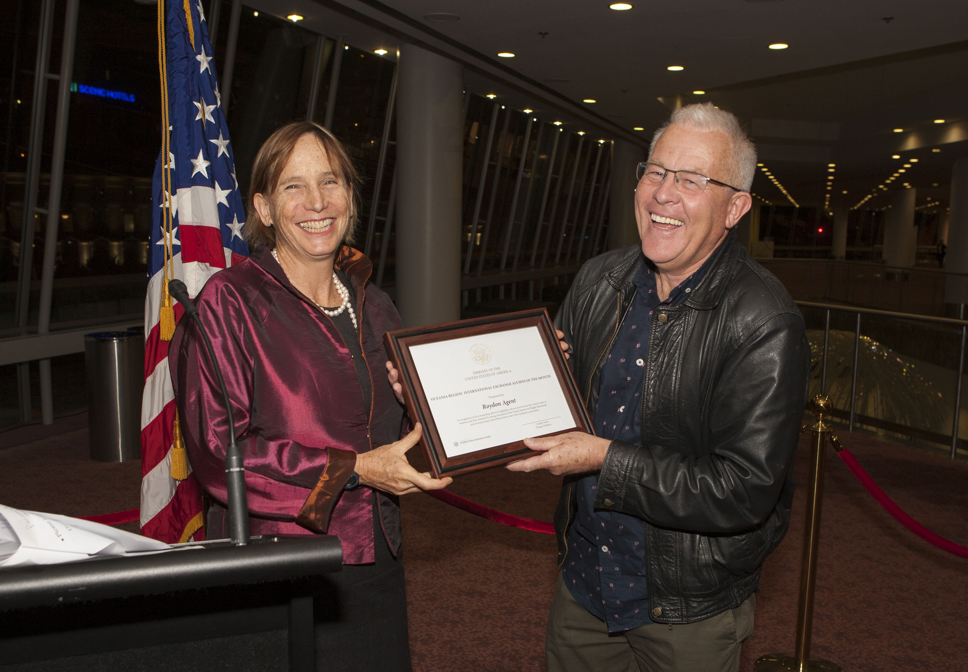 Man receiving a framed certificate from woman
