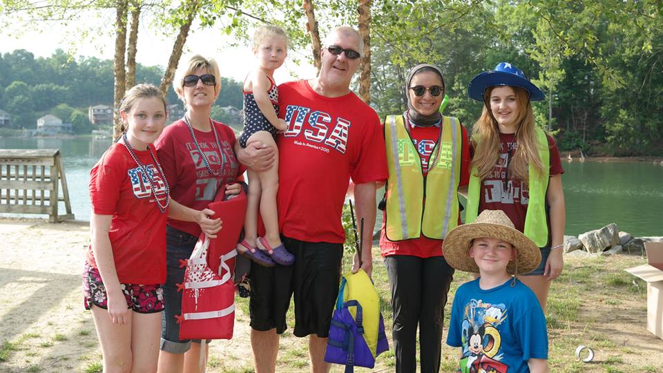 American host family with red USA shirts on standing with exchange participant