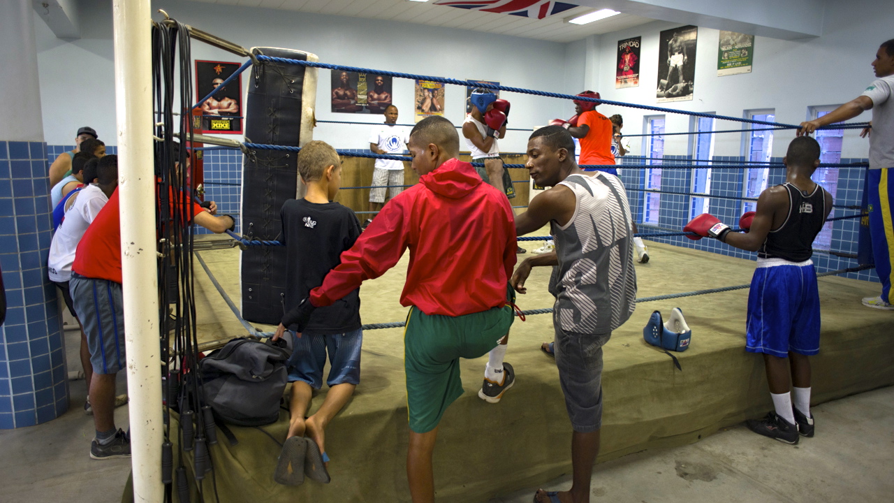 Boxers watching other boxers spar in boxing ring