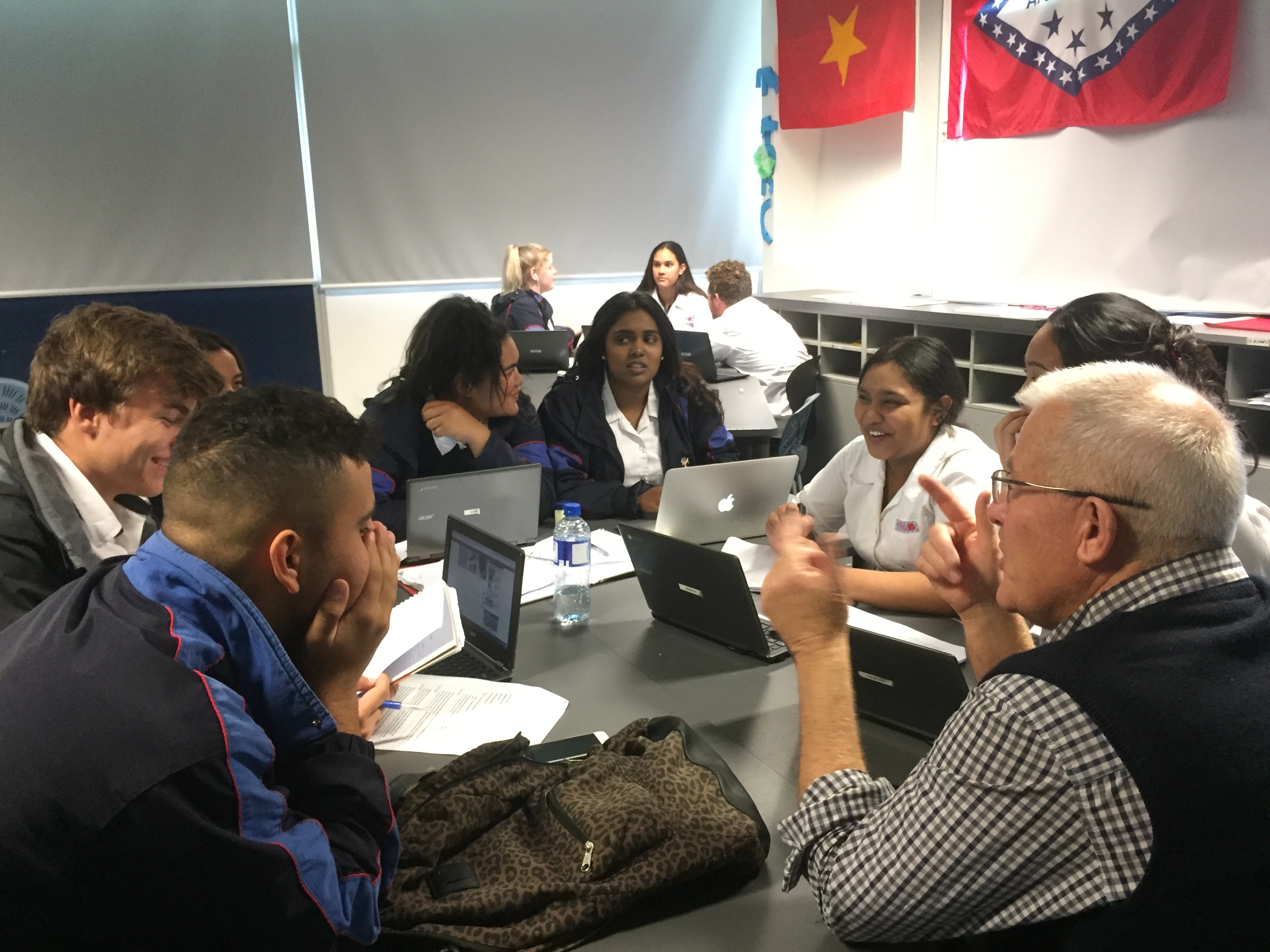 Man sitting with group of young adults in classroom