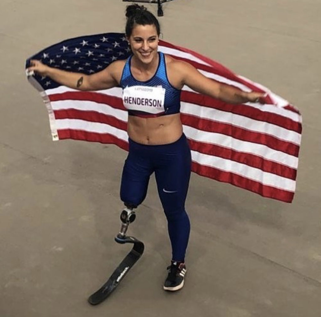 Track and field star Lacey Henderson poses with the American flag after competing in a track meet. 