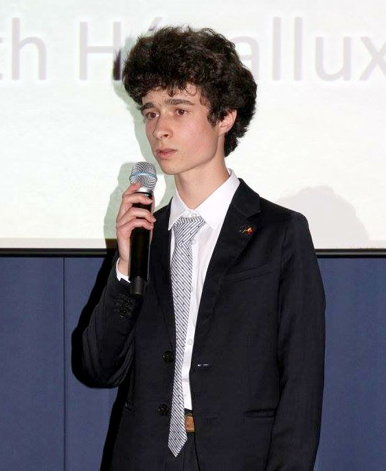 Young man stands on a stage holding a microphone