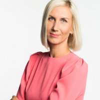 Mid shot of a woman standing with arms cross and a slight smile