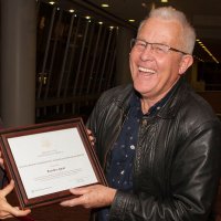 Man receiving a framed certificate