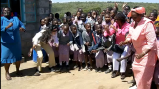 Maasai women and children greet American visitors.