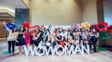 Group of women pose in front of letters reading "WoWoman"