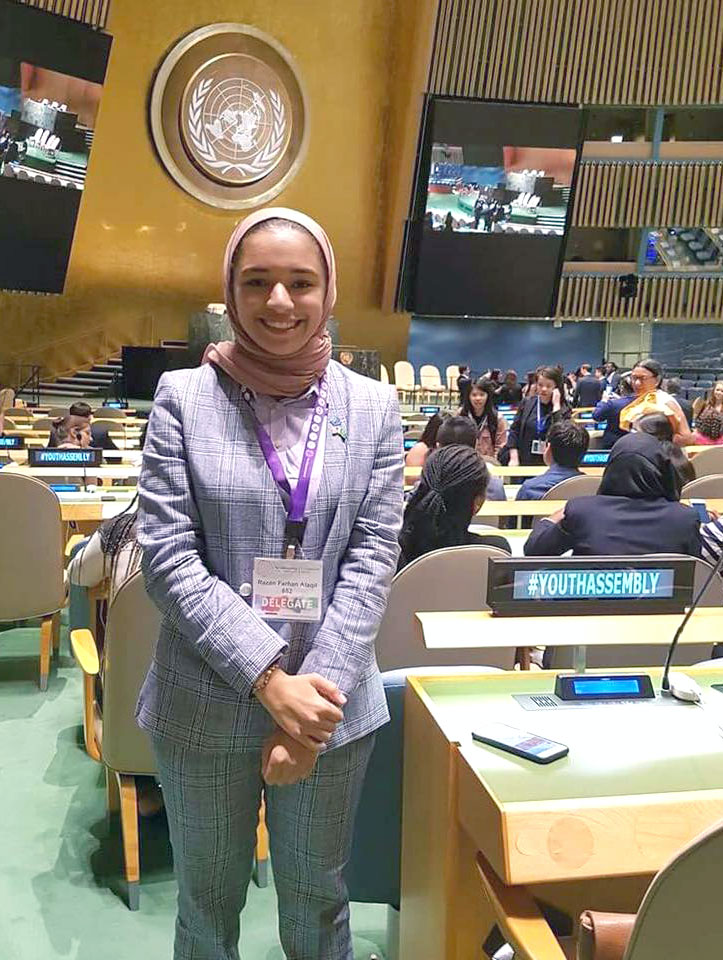 Young woman wearing a headscarf and business suit smiling in the conference hall of the United Nations